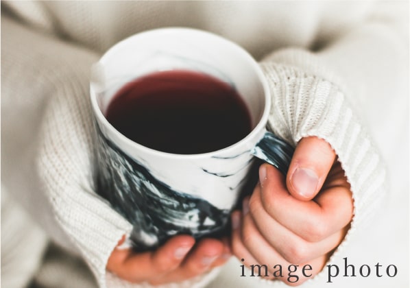 コーヒーカップを持つ手元の写真