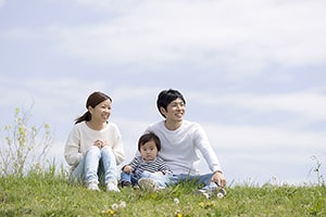 芝生の上でリラックスする家族